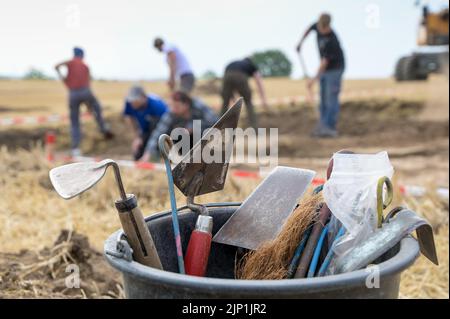 Helfta, Allemagne. 15th août 2022. Un seau avec des outils pour les fouilles archéologiques. De vastes fouilles archéologiques se poursuivent sur une superficie de 1500 mètres carrés. Sur le site de l'ancien palais royal près de Helfta, des bâtiments majestueux seront découverts cette année. Credit: Heiko Rebsch/dpa/Alay Live News Banque D'Images