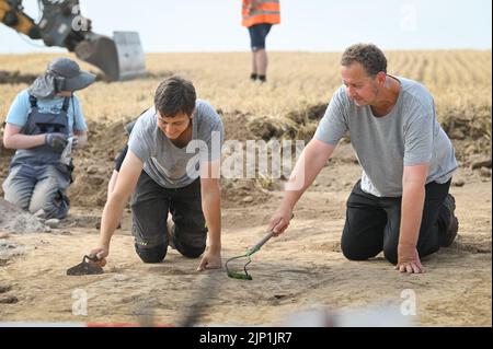 Helfta, Allemagne. 15th août 2022. Le directeur d'excavation Felix Biermann (r.) et l'étudiant David Herz découvrent des restes de mur avec des grattoirs. De vastes fouilles archéologiques se poursuivent sur une superficie de 1500 mètres carrés. Sur le site de l'ancien palais royal près de Helfta, des bâtiments majestueux seront découverts cette année. Credit: Heiko Rebsch/dpa/Alay Live News Banque D'Images