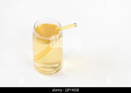 Boisson fermentée faite maison au kombucha dans du verre et paille réutilisable de couleur écologique sur fond blanc. Boisson probiotique heathy avec bulles. Boissons non alcoolisées en été. Copier l'espace Banque D'Images