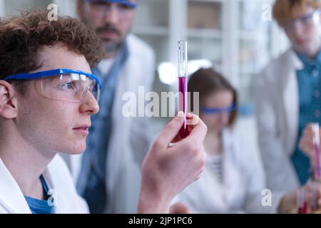 Étudiants en sciences avec un enseignant faisant des expériences chimiques en laboratoire à l'université. Banque D'Images