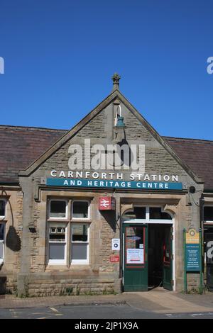 Gare de Carnforth et entrée principale du centre du patrimoine, extérieur du bâtiment avec panneaux associés et logo double flèche British Rail août 2022. Banque D'Images