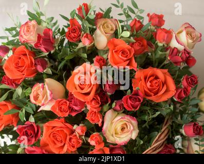Bouquet de roses rouges, orange, jaunes - une composition de roses multicolores. Arrière-plan d'une carte postale. Banque D'Images
