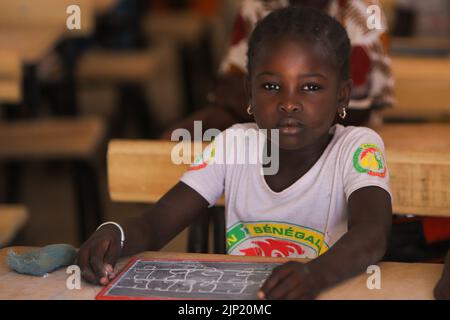 TORO, SÉNÉGAL - 4 FÉVRIER : une écolière dans sa classe avec un tableau noir dans ses mains à son bureau à l'école de 4 février 2020 à Toro, Sénégal (photo Banque D'Images