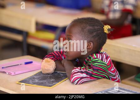 TORO, SÉNÉGAL - 4 FÉVRIER : une écolière dans sa classe avec un tableau de surveillance à son bureau à l'école de 4 février 2020 à Toro, Sénégal (photo de Peter van Banque D'Images