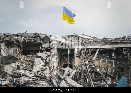 Bâtiment détruit. Vue sur les ruines. L'épave du bâtiment et le drapeau ukrainien Banque D'Images