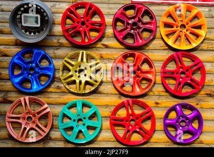 Ensemble de chapeaux de roue colorés sur le mur en bois. Ukraine, Odessa - service de voiture. Image d'arrière-plan. Banque D'Images