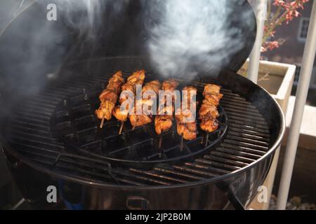 Un gros plan de délicieux brochettes de poulet grillées sur une grille de cuisson Banque D'Images