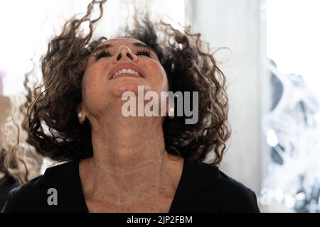 Photo avec mouvement d'une femme de beauté mûre agitant ses cheveux dans un salon de coiffure Banque D'Images