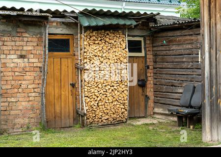 bois de chauffage empilé stocké dans un hangar en bois..vieux hangars ruraux en bois Banque D'Images