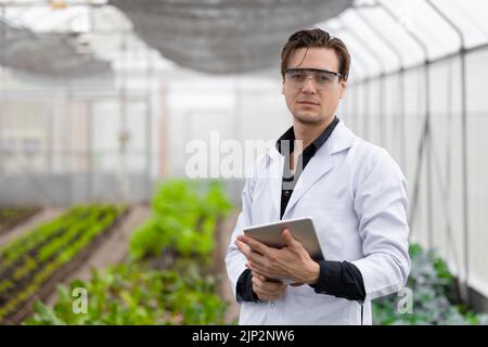 Portrait scientifique homme chercheur personnel travailleur collecte de l'information sur les plantes à l'étude dans une ferme agricole. Concept de science agricole. Banque D'Images
