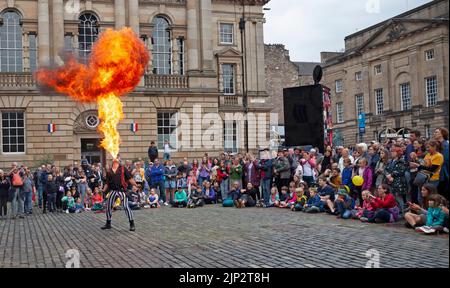 Parliament Square, Édimbourg, Écosse, Royaume-Uni 15th août 2022 Edinburgh Festival Fringe, Kumpania Phoenicia Fire Show, des États-Unis, Kumpania Phoenicia (Romani et grec pour la « famille Phoenix ») a accueilli un grand public avec leur feu de feu et leurs tours de boule de feu, ajoutant la lumière de bienvenue à une journée de temps très triste. Photo : Nathan Manchutta souffle une balle de feu. Crédit : Arch White/alamy Live News. Banque D'Images