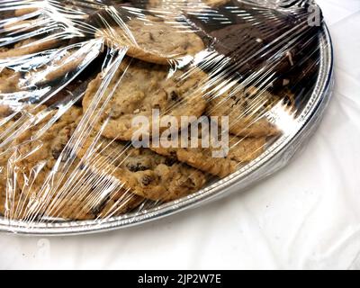 Beaucoup de biscuits sur une assiette sous emballage plastique pour un dessert frais Banque D'Images