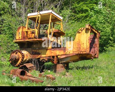 Vieux bulldozer rouillé abandonné dans l'environnement vert Banque D'Images