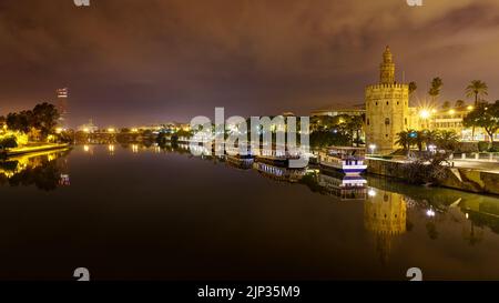 Guadalquivir rivière de Séville, scène nocturne avec des lumières dans la ville et des réflexions dans l'eau calme, paysage urbain panoramique. Andalousie, Espagne, Banque D'Images