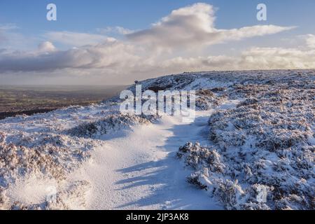 Paysages du Royaume-Uni : neige dans le Yorkshire à l'attraction touristique emblématique d'Ilkley Moor avec la pierre de Pancake et un sentier enneigé, West Yorkshire, Angleterre Banque D'Images