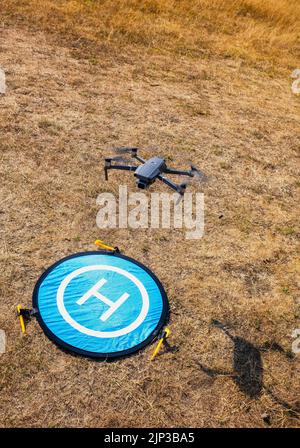 DJI Mavic 2 atterrissage de drone, à l'ombre, sur un mat portable, sur une pelouse parchée dans le champ de vol de Richmond Park, Londres Banque D'Images