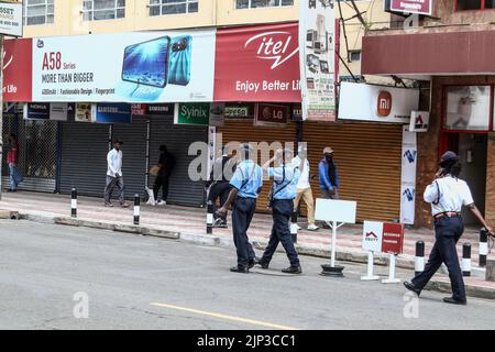 Nakuru, Kenya. 15th août 2022. Des policiers marchent à côté de boutiques fermées dans la ville de Nakuru avant l'annonce des résultats de l'élection générale du Kenya qui vient de se terminer. Les Kenyans attendent l’issue présidentielle des élections générales. Crédit : SOPA Images Limited/Alamy Live News Banque D'Images