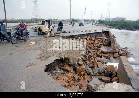 Vue de la destruction de la route de Korangi Crossing en raison de la stagnation de l'eau de pluie à l'origine d'un mauvais système d'assainissement créant des problèmes pour les navetteurs et les résidents, après que les inondations ont débordé dans la zone en raison de la forte marée basse de la saison de la mousson, située sur la rivière Mali Drain à Karachi lundi, 15 août 2022. Banque D'Images