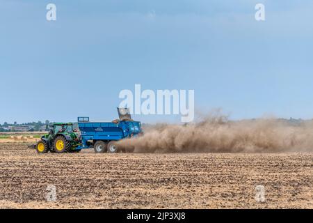 Aldreth, Cambridgeshire, Royaume-Uni. 15th août 2022. Un agriculteur répand de la chaux sur un champ arable, ce qui permet de tirer le meilleur parti du temps sec avant que des tempêtes de tonnerre et des pluies ne soient prévues dans une grande partie du Royaume-Uni. Les conditions arides provoquent des vols de poussière et le temps du Royaume-Uni devrait se refroidir avec les périodes de pluie. Crédit : Julian Eales/Alay Live News Banque D'Images