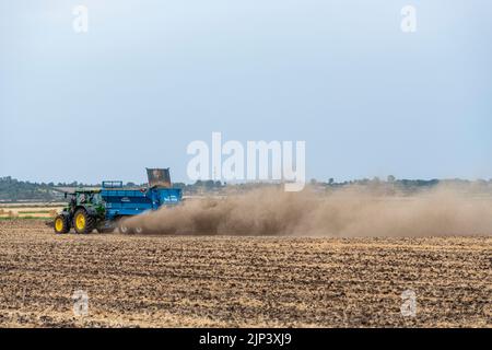 Aldreth, Cambridgeshire, Royaume-Uni. 15th août 2022. Un agriculteur répand de la chaux sur un champ arable, ce qui permet de tirer le meilleur parti du temps sec avant que des tempêtes de tonnerre et des pluies ne soient prévues dans une grande partie du Royaume-Uni. Les conditions arides provoquent des vols de poussière et le temps du Royaume-Uni devrait se refroidir avec les périodes de pluie. Crédit : Julian Eales/Alay Live News Banque D'Images