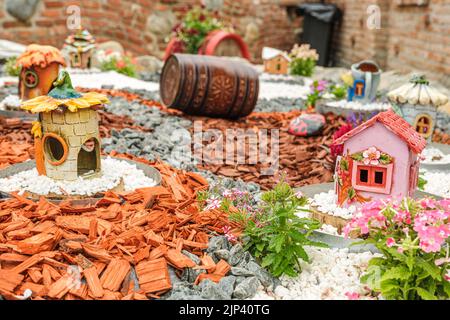 Aménagement de jardin avec des billes de bois, paniers en osier, gravier et divers ornements Banque D'Images