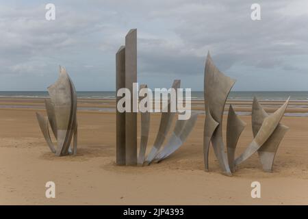 Sculpture historique des Braves sur Omaha Beach en Normandie avec un paysage aquatique en arrière-plan Banque D'Images