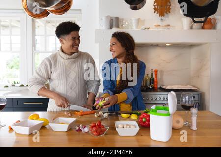 Image d'un couple heureux et varié préparant un repas dans la cuisine Banque D'Images
