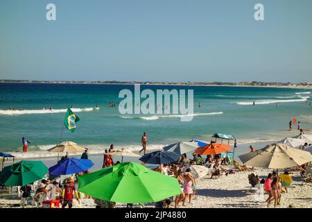 Des parasols et des touristes colorés se rassemblent sur la ligne de sable de Praia do forte. Banque D'Images