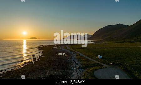 Vue aérienne au-dessus de la côte de Russelv, alpes de Lyngen, pendant le soleil de minuit en Norvège du Nord Banque D'Images