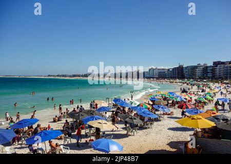 Des parasols et des touristes colorés se rassemblent sur la ligne de sable de Praia do forte. Banque D'Images