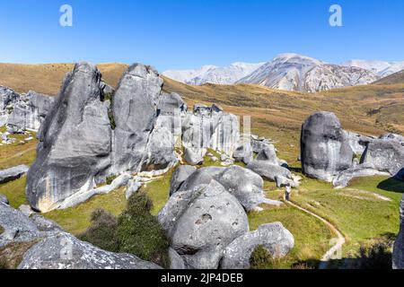 Personnes marchant parmi les formations rocheuses naturelles dans la zone de conservation de Castle Hill, près de Christchurch, Nouvelle-Zélande. Banque D'Images