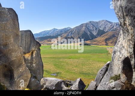 Vue sur les Alpes du Sud parmi les formations rocheuses naturelles de la zone protégée de Castle Hill, près de Christchurch, Nouvelle-Zélande. Banque D'Images
