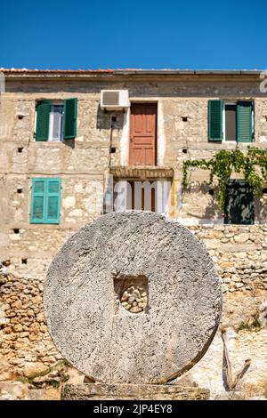 grande meule en pierre à l'extérieur d'une ferme grecque traditionnelle sur l'île de zante ou zakynthos en grèce, grande pierre utilisée pour meuler. Banque D'Images