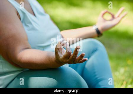 Gros plan d'une femme noire en surpoids faisant du yoga à l'extérieur et méditant en se concentrant sur la pose à la main, l'espace de copie Banque D'Images