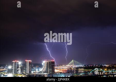 Ciel très nuageux, foudre et tonnerre au-dessus du ciel de Belgrade (capitale de la Serbie), vue panoramique sur la ville et la rivière avec des ponts. Banque D'Images