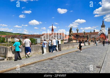 Würzburg, Allemagne - juin 2022: Touristes à l'ancien pont principal appelé 'Alte Mainbrücke', un symbole de la ville et célèbre attraction touristique Banque D'Images