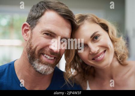 C'est le compagnon idéal. Portrait d'un heureux couple d'âge moyen passant du temps ensemble à la maison. Banque D'Images