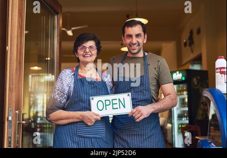 Bien être ouvert tous les jours pour beaucoup plus de générations. Portrait court d'une femme mûre et de son fils adulte debout sur le chemin d'entrée de leur glace familiale Banque D'Images