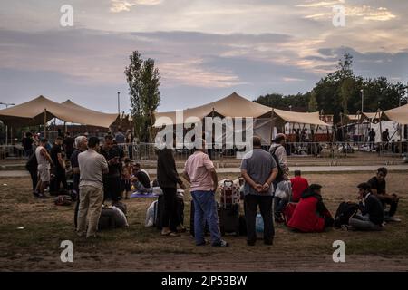 2022-08-15 20:52:25 TER APEL - demandeurs d'asile attendent un bus à un abri d'urgence à l'extérieur de l'abri de fortune à l'extérieur de la porte du centre de demandeurs d'asile de l'ACO quand un orage se développe. L'Agence centrale pour l'accueil des demandeurs d'asile (AOC) s'attend à ce qu'environ 150 personnes aient à dormir à l'extérieur au centre d'application de Ter Apel à cause de la foule. ANP VINCENT JANNINK pays-bas sortie - belgique sortie Banque D'Images