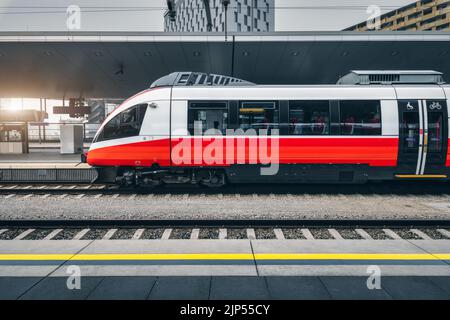 Train à grande vitesse sur la gare de Vienne, Autriche. Beau train de voyageurs interurbain moderne rouge sur le quai ferroviaire. Le chemin de fer en Europe Banque D'Images