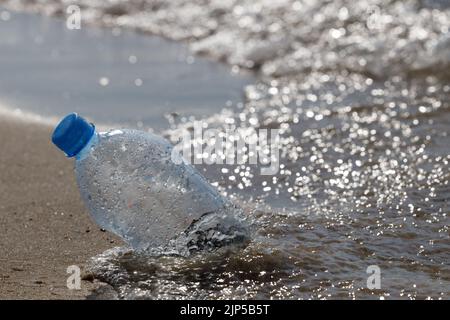 Pollution des bouteilles en plastique sur la plage de sable. Les poubelles en plastique pour animaux de compagnie sont laissées sur la plage de sable Banque D'Images