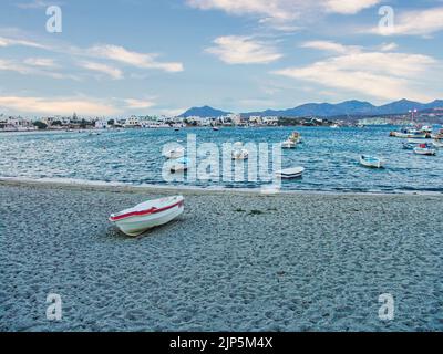 Un petit port avec des bateaux de pêche et des eaux turquoise cristallines dans le village de Pollonia sur l'île de Milos, Grèce Banque D'Images