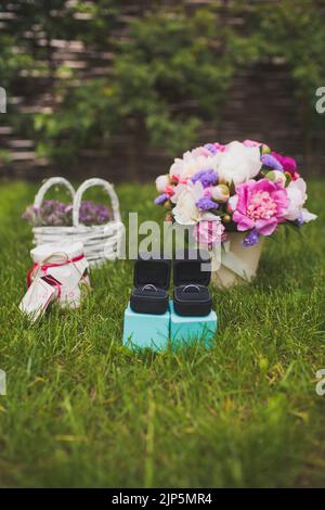 Deux anneaux de mariage dans des boîtes sur l'herbe. Banque D'Images