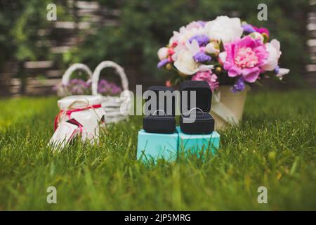 Deux anneaux de mariage dans des boîtes sur l'herbe. Banque D'Images