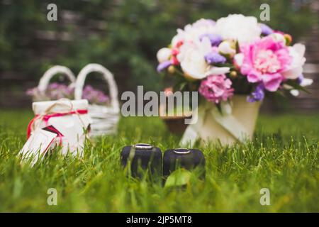 Deux anneaux de mariage dans des boîtes sur l'herbe. Banque D'Images