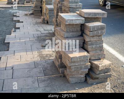 Une pile de pavés au sol. Travaux routiers. Pose de carreaux sur le trottoir. Travaux de construction Banque D'Images