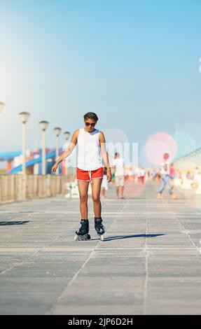 Le rollerblading est un excellent moyen de rester en forme. Une jeune femme attirante rollerblading sur une promenade. Banque D'Images