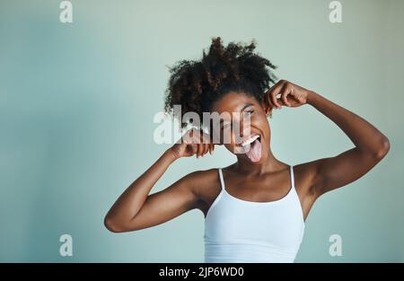 Soyez stupide, quoi que vous fassiez, soyez fidèle à vous. Photo studio d'une jeune femme au beau devant, se posant sur un fond vert. Banque D'Images