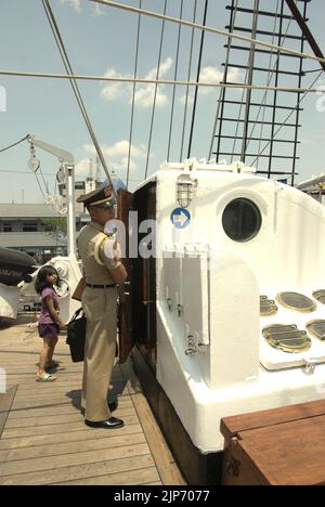 Un enfant visiteur faisant attention à un cadet de la marine indonésienne qui ouvre la porte de la chambre du cadet sur le KRI Dewaruci (Dewa Ruci), un grand navire indonésien, tandis que la goélette de type barquentine est ouverte aux visiteurs publics au port de Kolinlamil (port de la marine) à Tanjung Priok, dans le nord de Jakarta, en Indonésie. Banque D'Images