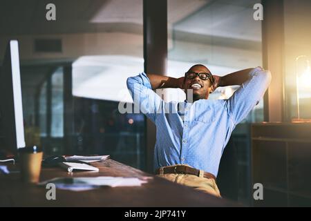 Un beau jeune homme d'affaires qui se détend à son bureau tard dans la nuit au travail. Banque D'Images